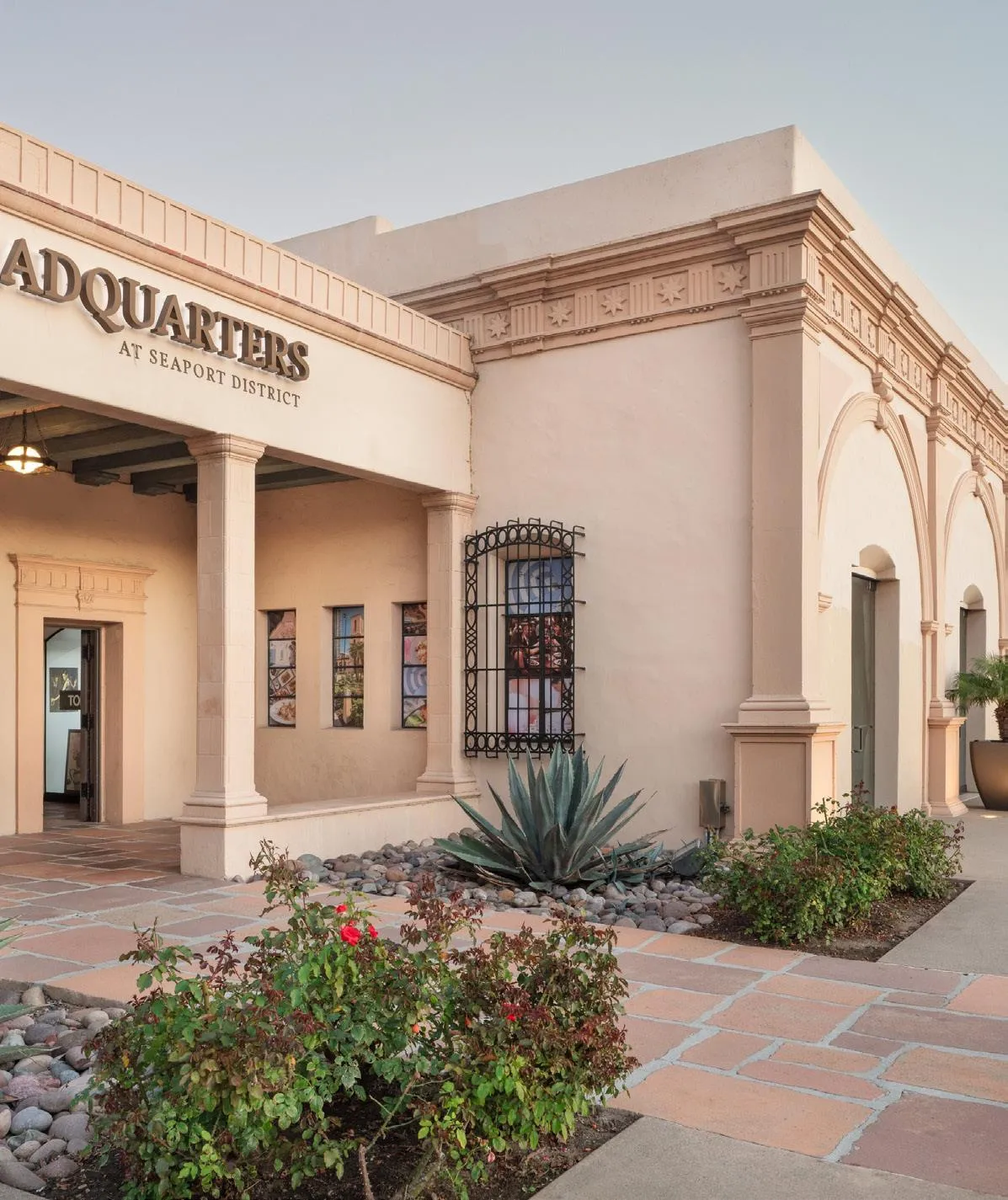 Front facade of The Headquarters with arched entry and agave planting