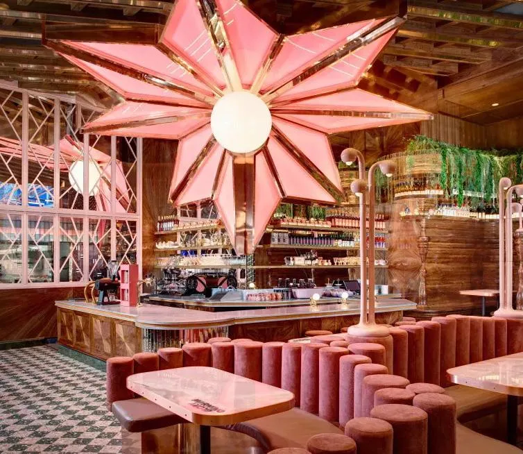 Restaurant interior with a pink star chandelier and banquette seating