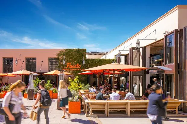 Puesto patio with orange umbrellas and guests