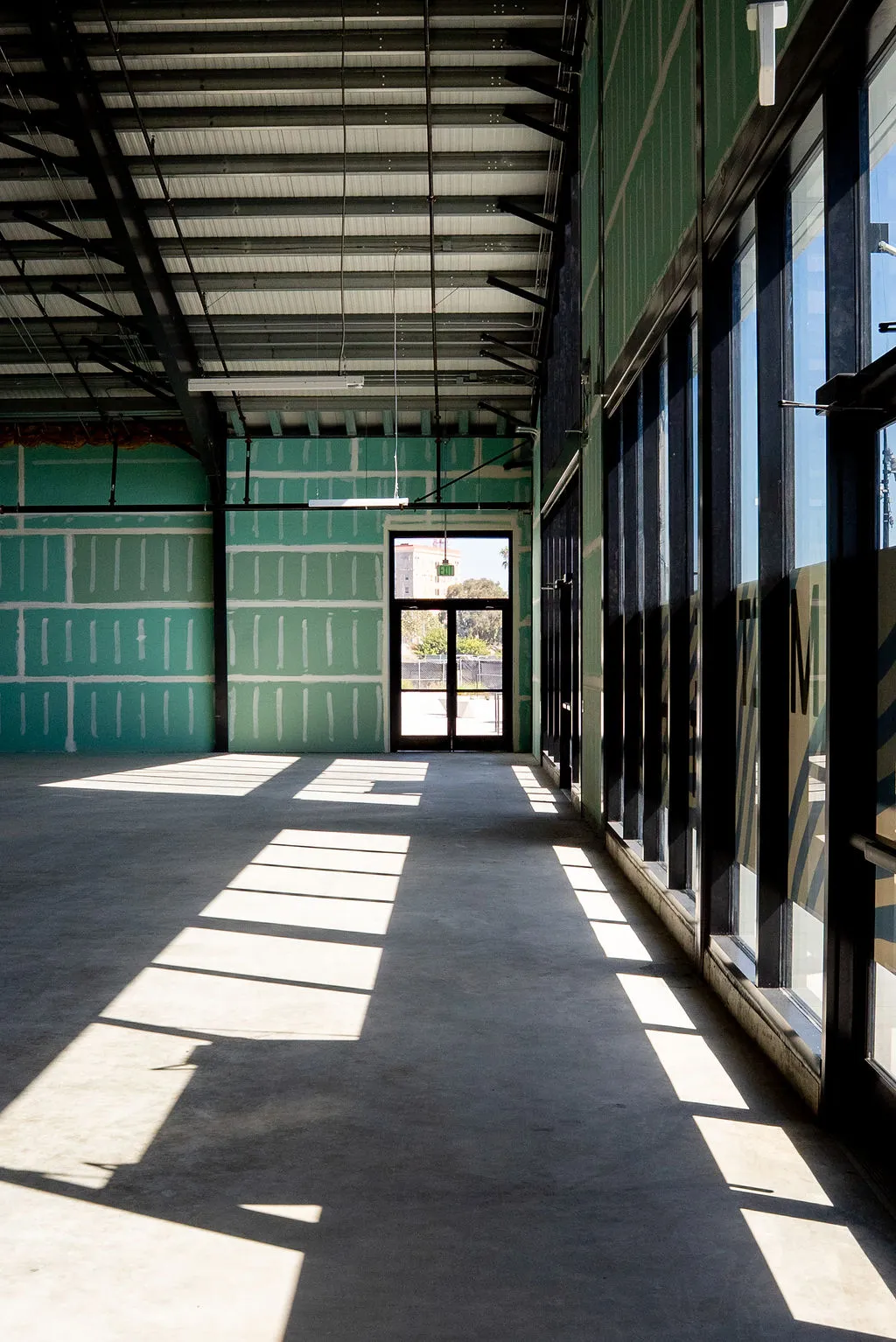 Covered arcade along a tenant space, with light falling through the structure